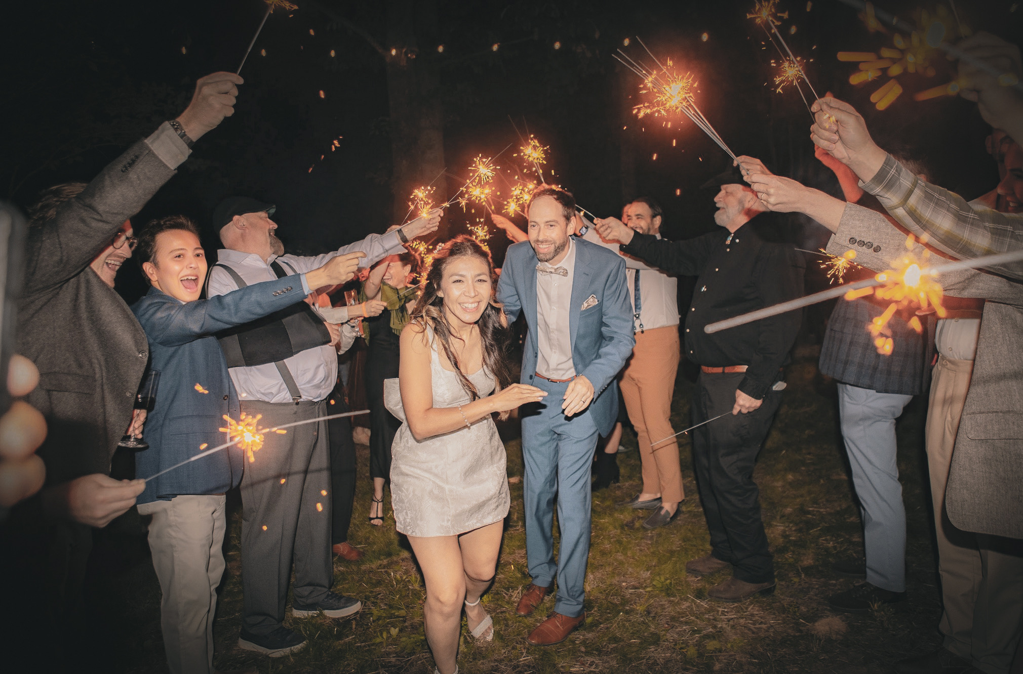 Outdoor wedding reception with string lights at twilight on the ridge